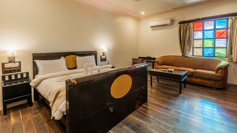 an image of a bedroom with a living space and a fan hanging from the ceiling.